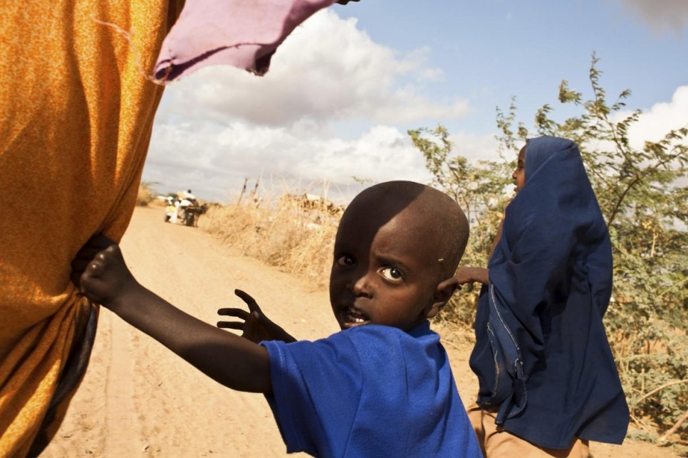 Une mère et ses deux enfants suivent une charrette tirée par un âne et chargée des biens de la famille près du camp d'Ifo à Dadaab, au Kenya. Ils ont quitté la Somalie en raison de la guerre civile et des conséquences de la sécheresse et de la famine. 