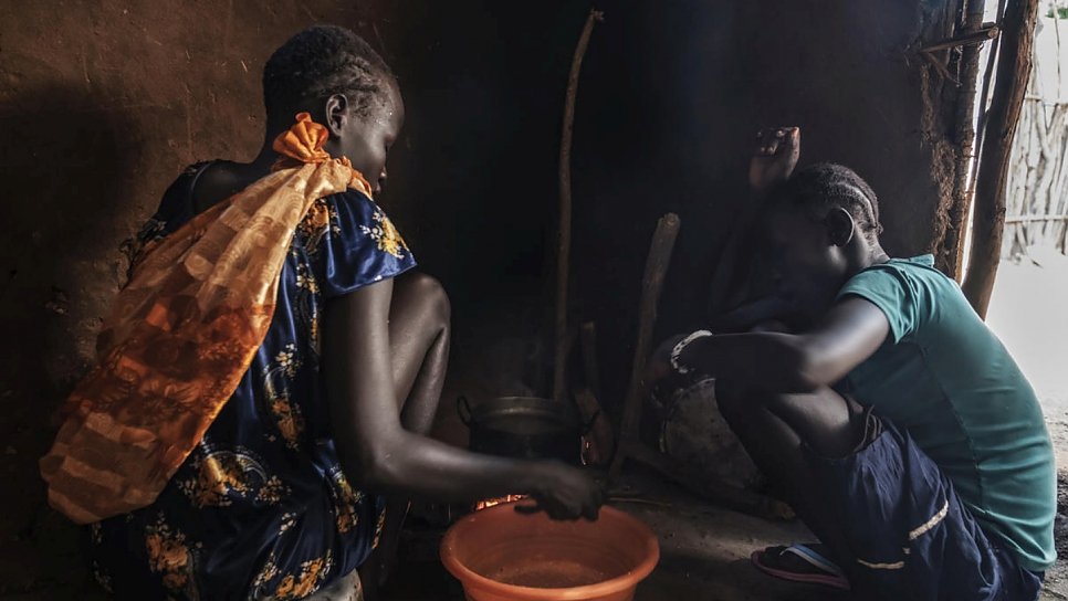 Unaccompanied South Sudanese minors, 16-year-old Nyamach Lul (left) and 13-year-old Nyakoang (right) prepare food at home in Jewi refugee camp, Ethiopia.