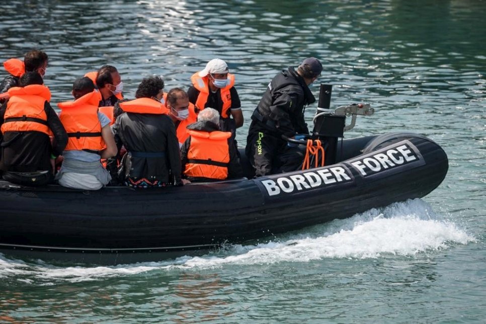 Des réfugiés et des migrants arrivent au port à bord d'un zodiac des gardes-frontières après avoir été interceptés lors de la traversée de la Manche depuis la France à bord de petites embarcations le 11 août 2020 à Douvres, en Angleterre