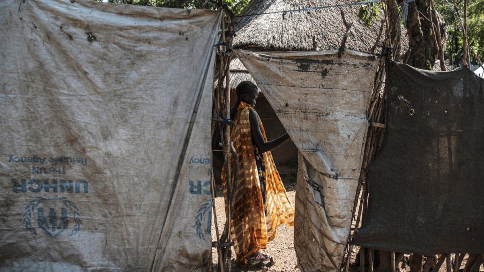 Unaccompanied South Sudanese minor, 16-year-old Nyamach Lul, stands in the doorway of the house she shares with her 13-year-old sister Nyakoang, in Jewi refugee camp, Ethiopia.