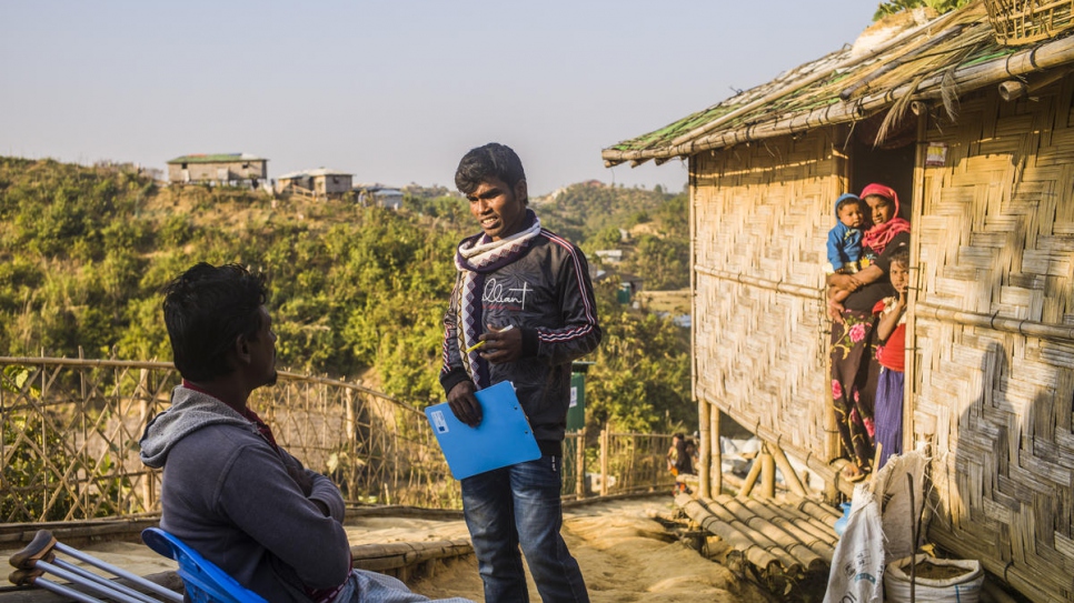 Rohingya volunteer Mohammed Halim, rights, talks with Nessar Ahmed in Camp 21, Teknaf, Bangladesh.