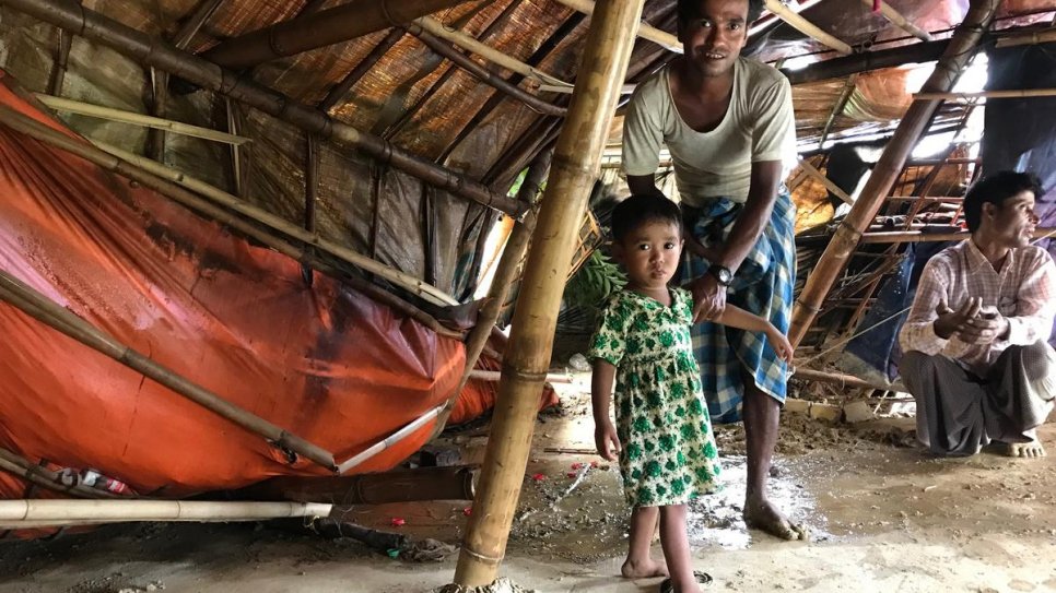 Mohammed Rafiq and his two-year-old daughter, Noor Fatima, inspect their shelter damaged by a landslide at Chakmarkul settlement, Bangladesh. 