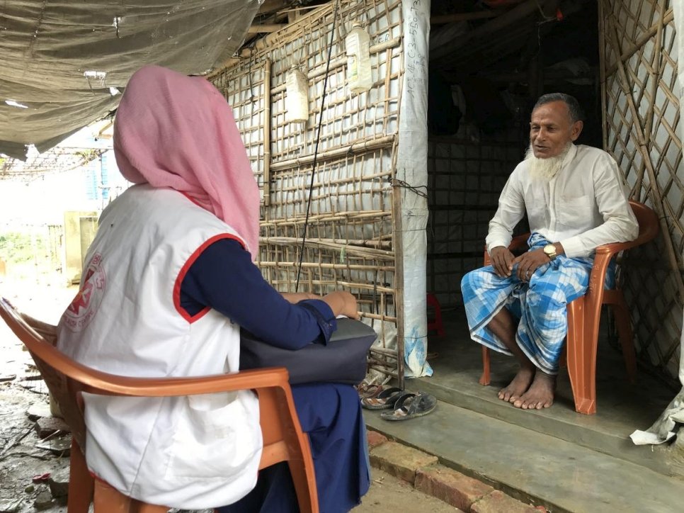 A Rohingya refugee trained as a community health worker visits a household in her community to raise awareness about COVID-19.