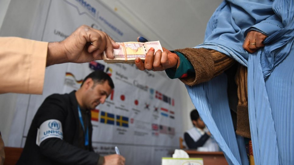 An Afghan woman receives her third installment of cash to build a shelter in Kandahar province, on 2 February, 2020.
