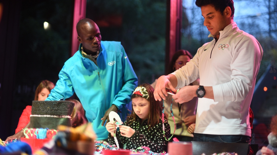 Le nageur Rami Anis et le coureur Yiech Pur Biel, qui ont concuru aux Jeux olympiques de Rio 2016 au sein de l'Equipe olympique des athlètes réfugiés, participent à des activités avec des enfants au Musée du Quai Branly, à Paris, le 18 décembre 2016, lors d'une journée d'activités organisée par le HCR et Aviation Sans Frontières, pour livrer des jouets collectés pour des enfants dans un camps de réfugiés au Soudan du Sud.