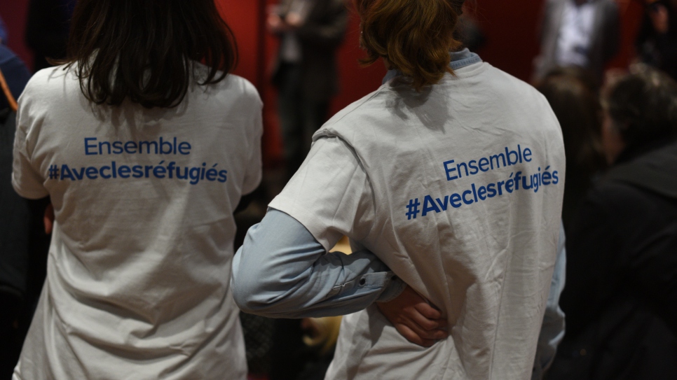 Des bénévoles du HCR se tiennent debout lors d'une journée d'activités organisée par le HCR et Aviation Sans Frontières pour livrer des jouets collectés pour des enfants dans un camps de réfugiés au Soudan du Sud, le 18 décembre 2016.