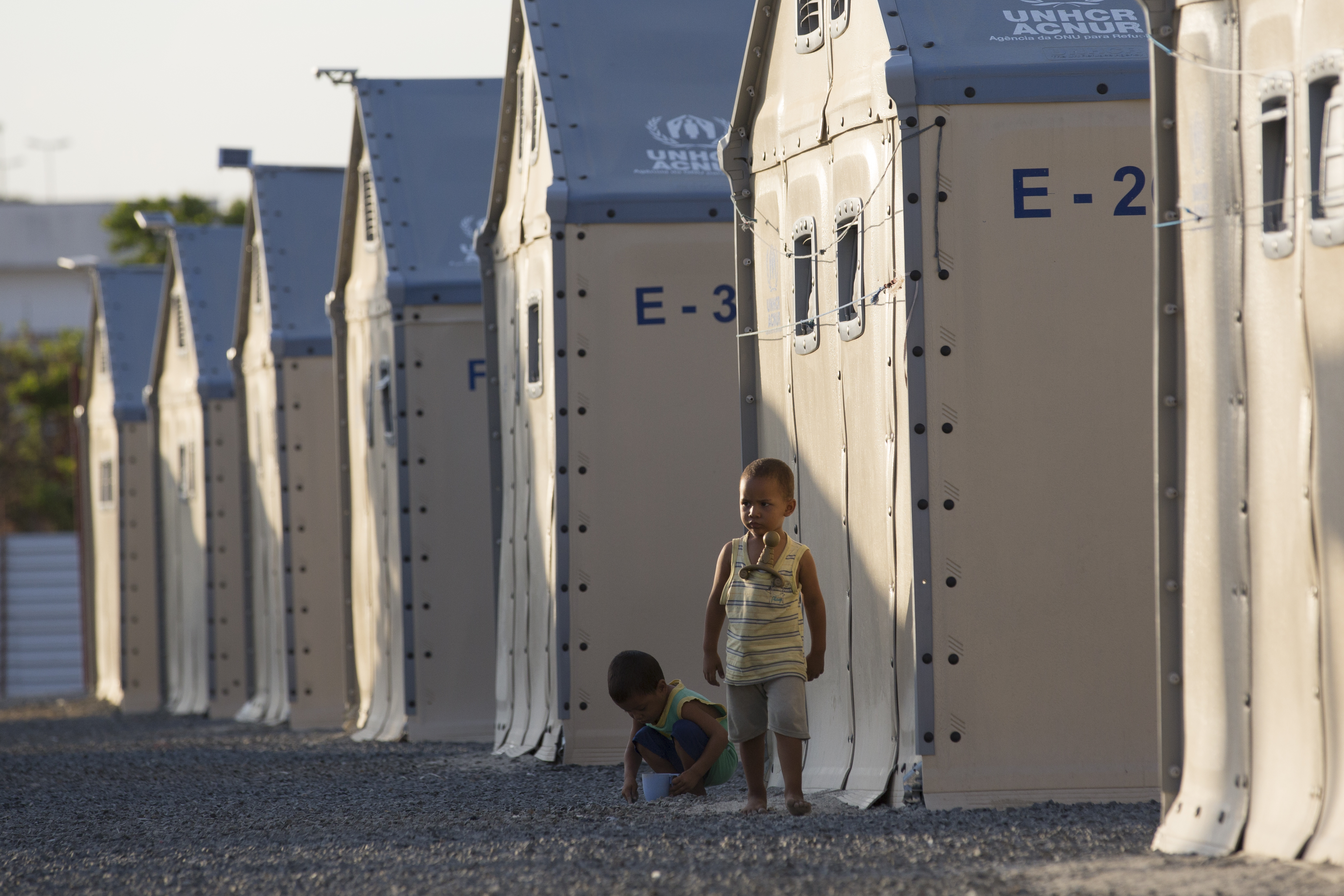 Kinderen spelen in een vluchtelingenkamp in Brazilië waar UNHCR prefab woningen heeft gebouwd