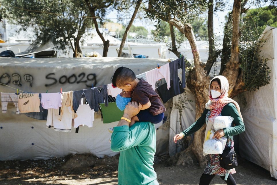 Une famille afghane se déplace dans un camp informel situé en périphérie du centre de réception et d'identification de Moria, sur l'île de Lesbos. 1er septembre 2020. 