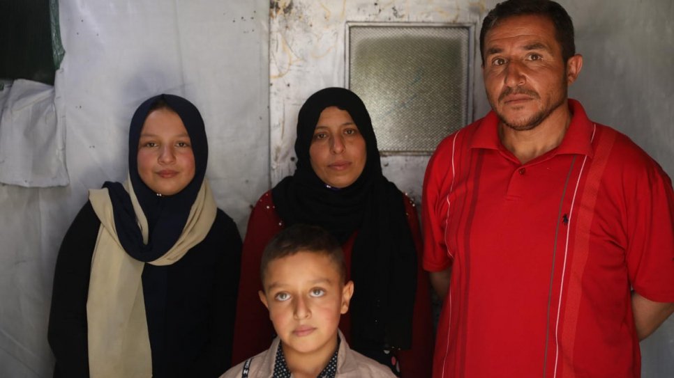 Khalil (à droite) avec sa famille, dont sa fille Nahed (à gauche), âgée de 12 ans, qui a abandonné l'école pour gagner de l'argent grâce à la cueillette des légumes. 