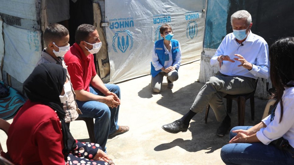 Filippo Grandi s'entretient avec Khalil et sa famille devant leur abri dans un campement informel de la plaine de la Bekaa, au Liban. 