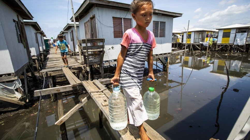 Une fillette en train de porter de l'eau dans la communauté de réinstallation de Valle Vista, près de Zamboanga, Philippines. La communauté est composée de deux groupes ethniques, les Sama Bajau et les Tausug. 