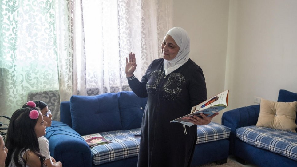 L'Ambassadrice de We Love Reading, Latifa Al-Laham, 55 ans, fait la lecture à un groupe de jeunes réfugiés syriens dans un appartement à Amman, en Jordanie. 