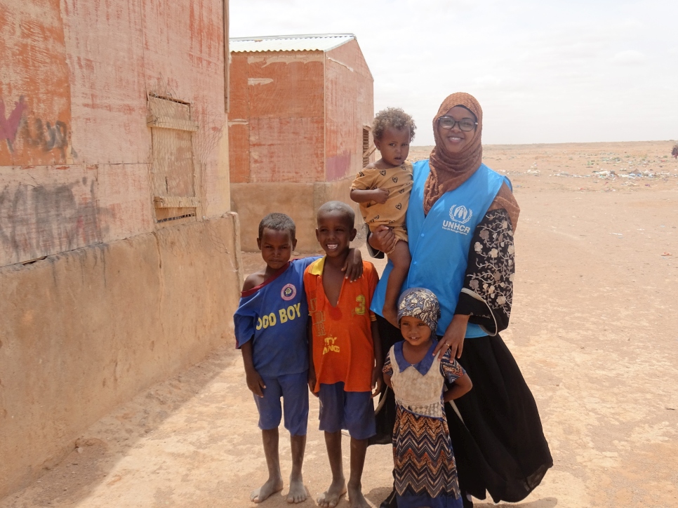 Bisharo Hussein (left) poses with young children in Galkacyo, Somalia where she works as a Protection Associate.