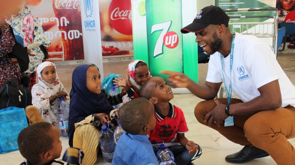 Louis Lithur, jeje de la oficina de ACNUR en Jijiga, ríe con un grupo de niños recién llegados en Dire Dawa, en Etiopía.
