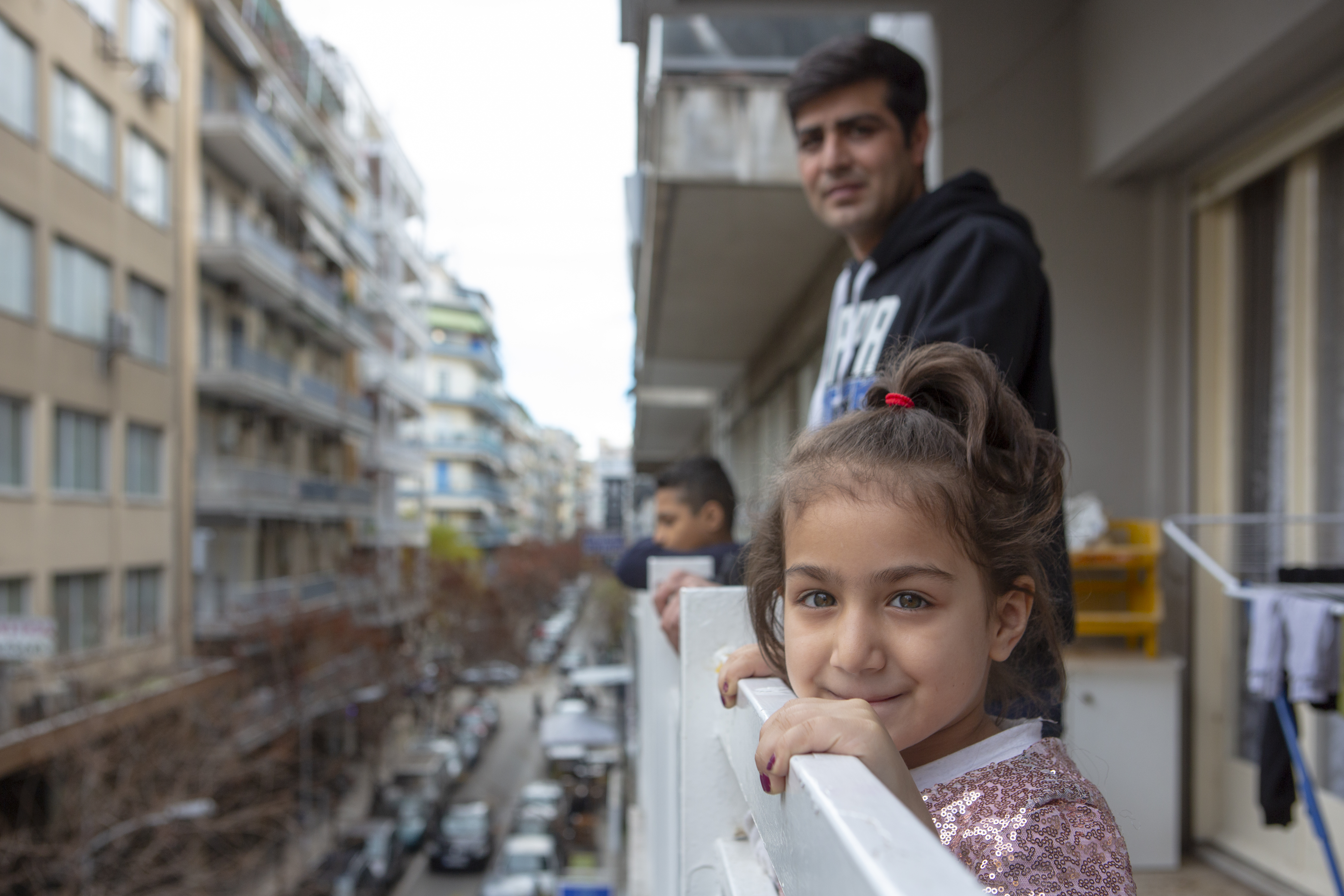 Ragazzi che si affacciano dal balcone di un palazzo - I rifugiati