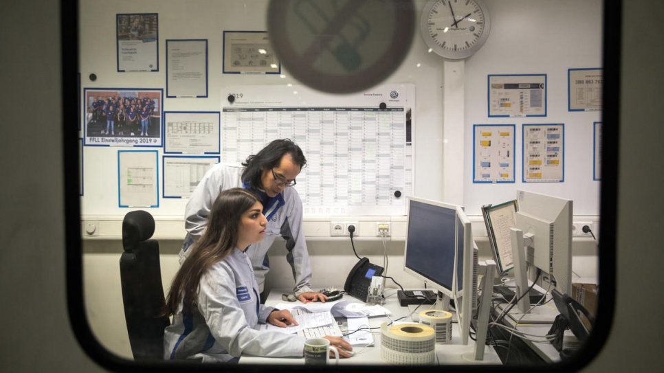 Mastura at work at the VW logistics centre in Baunatal, Germany. She is supported by Johannes Gerhard, her training officer.