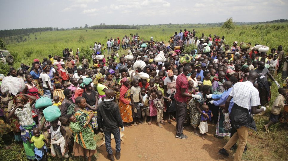 Des demandeurs d'asile de la République démocratique du Congo sont en attente de se soumettre à un contrôle sanitaire à la frontière à Zombo, en Ouganda. 