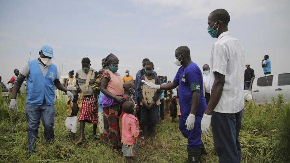 Les réfugiés et les demandeurs d'asile congolais se soumettent à un examen de santé près de la frontière à Zombo, en Ouganda, dans le cadre des mesures visant à prévenir la propagation du Covid-19 dans le pays. 