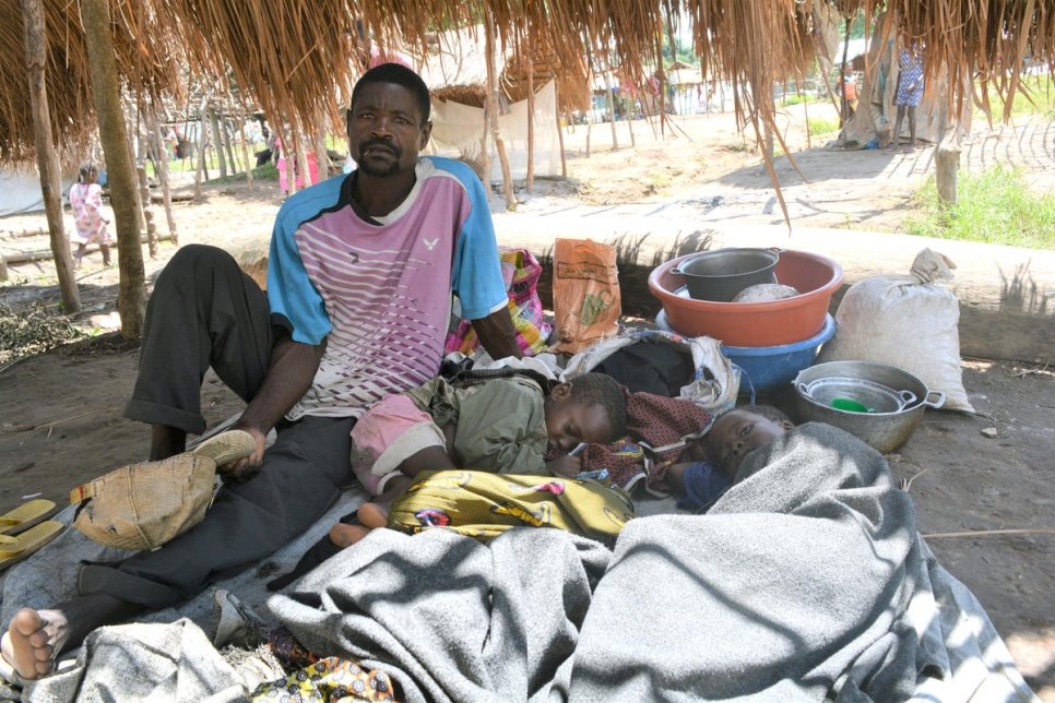 Un père réfugié de la République démocratique du Congo est assis à côté de ses trois enfants malades à Toko Kota, en République centrafricaine. 