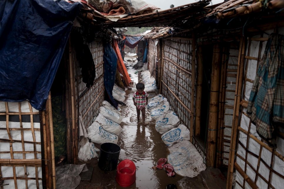 Un enfant réfugié rohingya joue dans une zone inondée entre des abris, dans l'installation de réfugiés de Shamlpur au Bangladesh.  