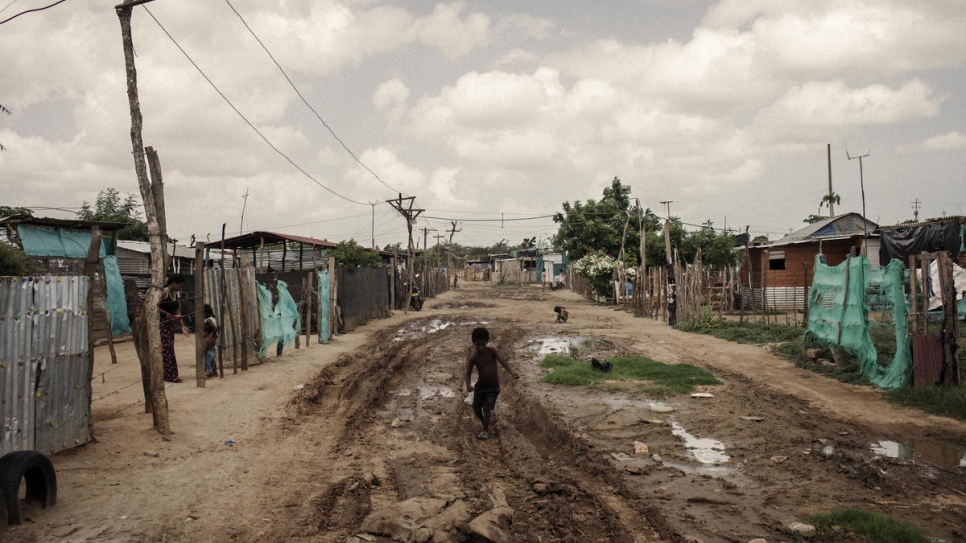 Un niño juega en una calle destapada en una comunidad en el noreste de Colombia, donde viven miles de venezolanos.