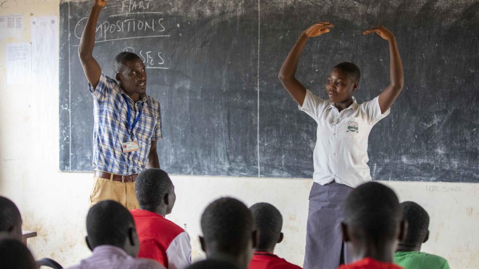 A school teacher leads a class with a student in Makpandu settlement, South Sudan.