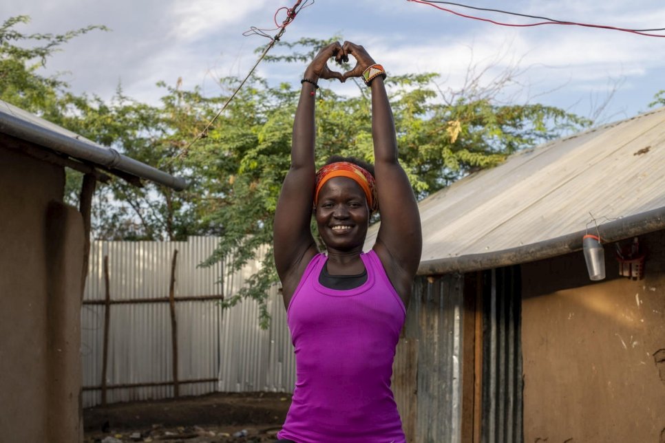 Rita Brown, réfugiée ougandaise et instructrice de yoga, prend une pose de yoga à l'extérieur de son logement dans le camp de Kakuma, au Kenya. 