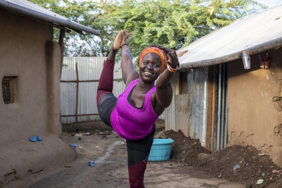 Rita Brown, réfugiée ougandaise et instructrice de yoga, prend une pose de yoga à l'extérieur de son logement dans le camp de Kakuma, au Kenya. 