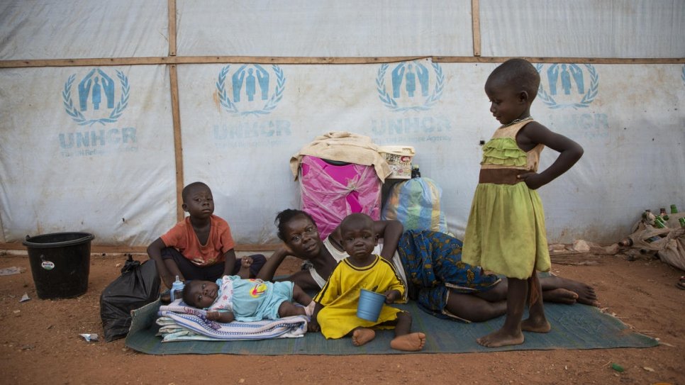 An Anglophone refugee family from Cameroon wake up outdoors on a mat at the Agadom Refugee Settlement in Ogoja, Nigeria.