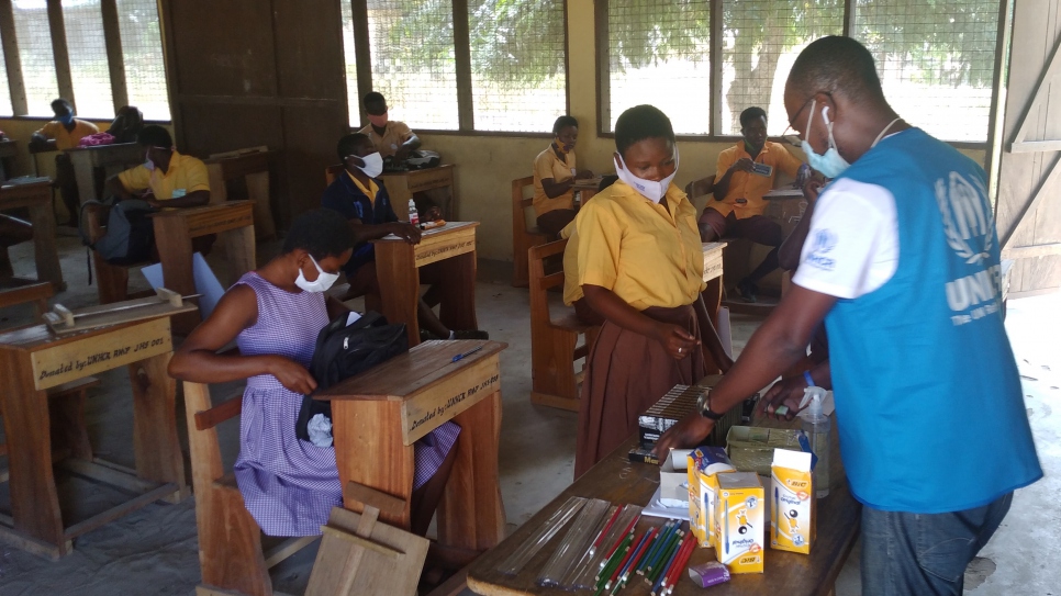 Final year students observe social distancing as they receive stationery ahead of their finals at Ampain community school in Ghana.