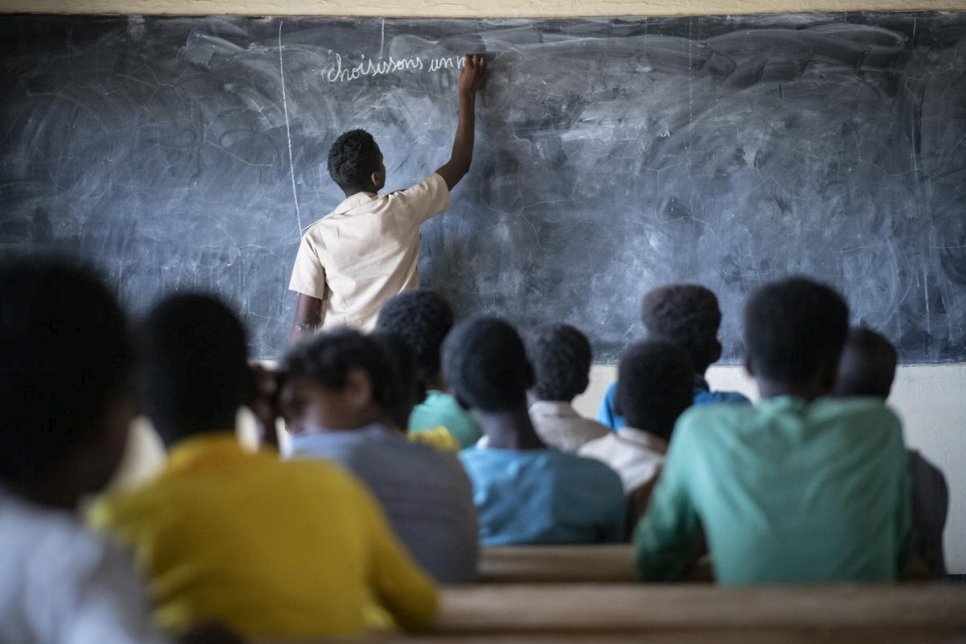 Un élève réfugié malien joue le rôle d'un enseignant dans une école du camp de Goudoubo. En raison de l'insécurité croissante, les enseignants ne se présentent plus et ce sont souvent des élèves qui se chargent de l'enseignement. 