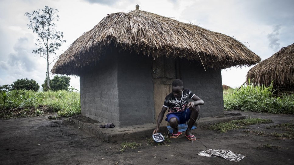 Gift, un réfugié sud-soudanais de 10 ans, met la lampe solaire qu'il a fabriquée tout seul à recharger pour pouvoir étudier une fois la nuit venue. Il fréquente l'école du camp de réfugiés de Biringi, en République démocratique du Congo. 