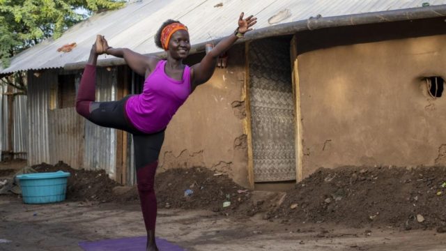 Rita Brown, réfugiée ougandaise et professeure de yoga, exécute un mouvement de yoga devant son logement dans le camp de Kakuma, au Kenya.