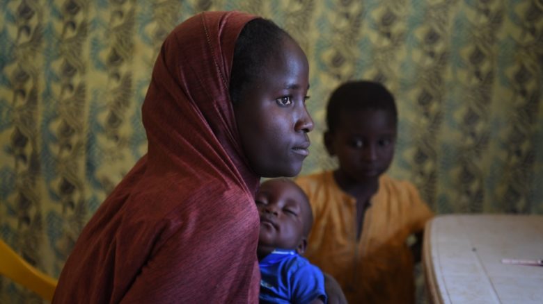 Une femme tient un bébé.