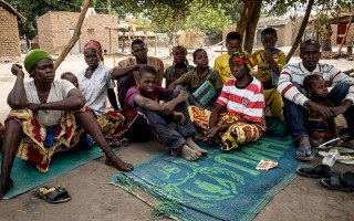 Jacob and his family rest by a tree in their new home in Chad.