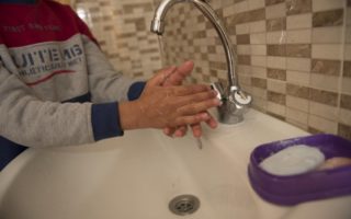 An unidentified child washes their hands with soap and water