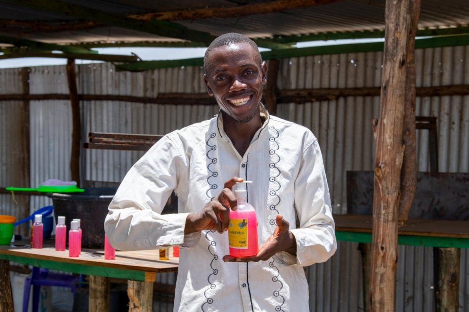 Innocent Havyarimana, un producteur de savon burundais, tient un récipient de désinfectant pour les mains fraîchement fabriqué, qu'il vend à prix réduit à ses pairs réfugiés à Kakuma, aux travailleurs humanitaires et aux Kényans de la communauté locale, pour aider à la lutte contre la crise de Covid-19. 