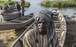 A man sits on a fishing boat