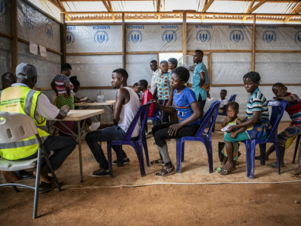 Cameroon refugees sit in line for registration