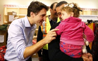 Des réfugiés syriens sont accueillis par le Premier ministre du Canada, Justin Trudeau (à gauche sur la photo), à leur arrivée à l'aéroport international Pearson de Toronto.