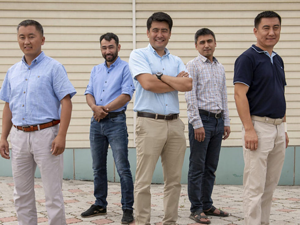 Nansen refugee award winner stands with other men in Kyrgyzstan