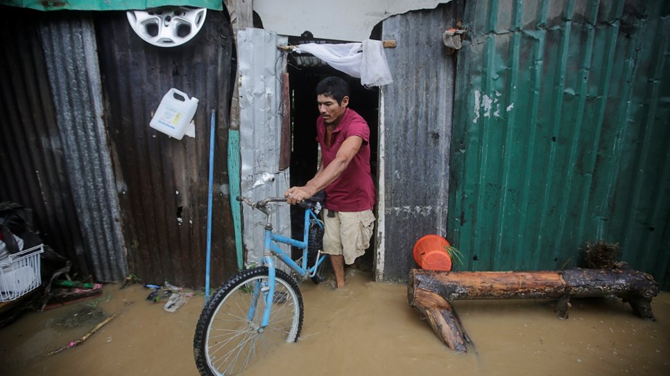 Un homme quitte sa maison inondée, après le passage de l'ouragan Eta, à Tela au Honduras (4 novembre 2020). 