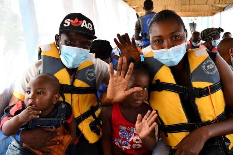 Des réfugiés centrafricains saluent de la main alors que le bateau qui les transporte vers leur pays d’origine quitte Zongo en République démocratique du Congo. Novembre 2020