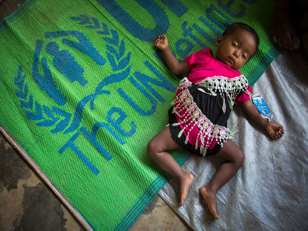 Un bébé dort sainement parmi quelque 5 000 personnes déplacées vers un nouveau site près du camp de réfugiés de Kutupalong. © HCR / Roger Arnold