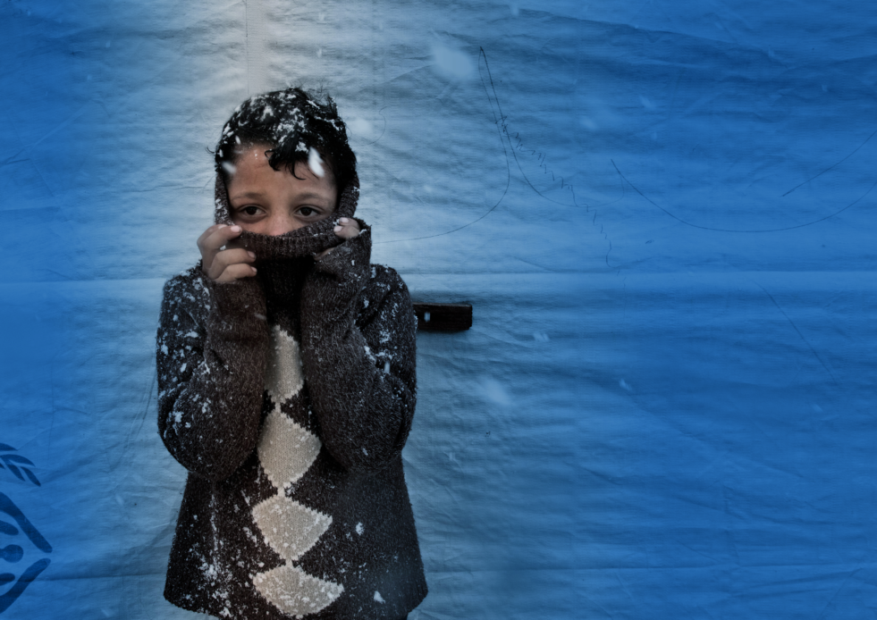 Boy holding up scarf, in snow