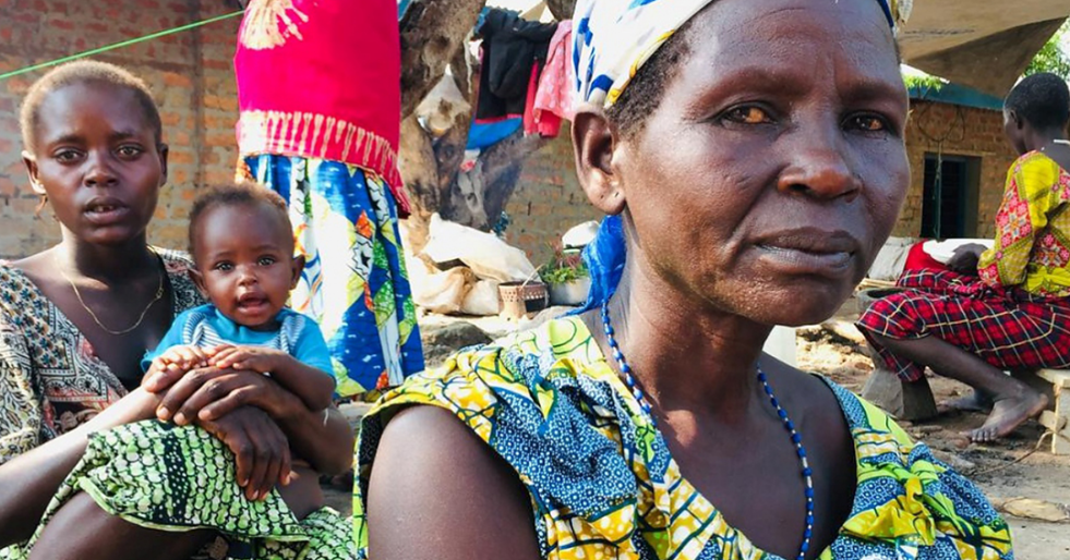 A woman from the DRC sits somberly looking into the camera