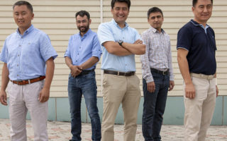 Nansen refugee award winner stands with other men in Kyrgyzstan