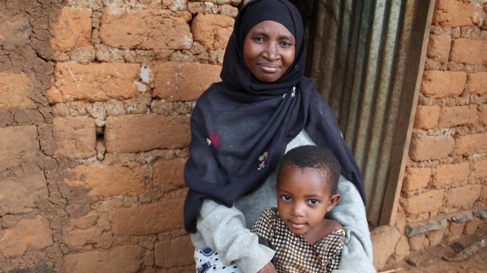 Venancia Nibitanga, réfugiée burundaise, avec sa plus jeune fille devant chez elle, dans le camp de réfugiés de Nduta, en Tanzanie. 