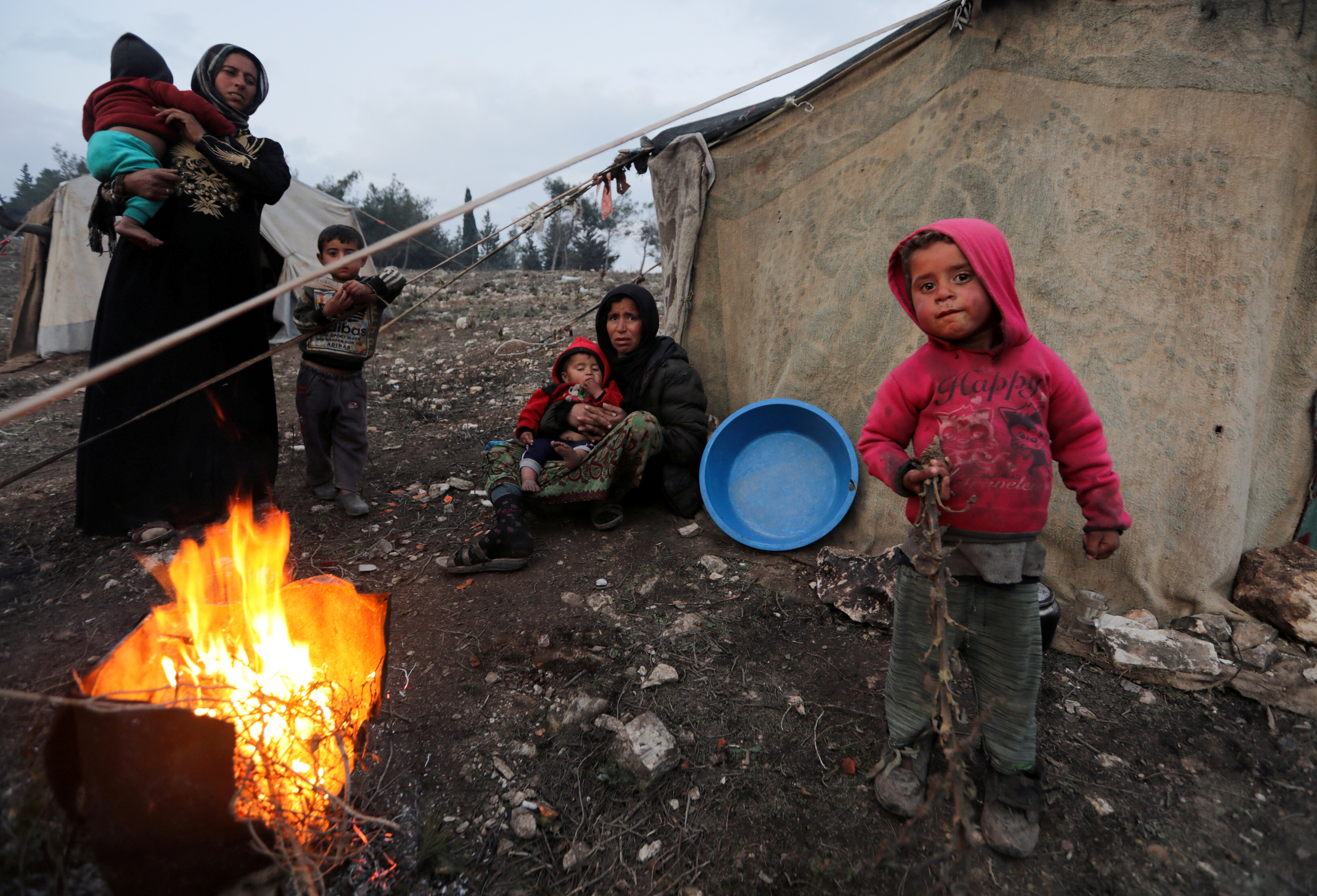 Syria. Displaced Syrian women and children, who fled from southern Idlib, gather around a fire in Afrin