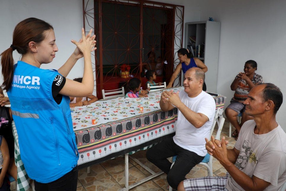 Venezolaanse vluchtelingen en migranten oefenen met handdesinfecterend middel dat door UNHCR-beveiligingspersoneel wordt uitgedeeld in een opvangcentrum in Manaus, Brazilië. © UNHCR/Felipe Irnaldo